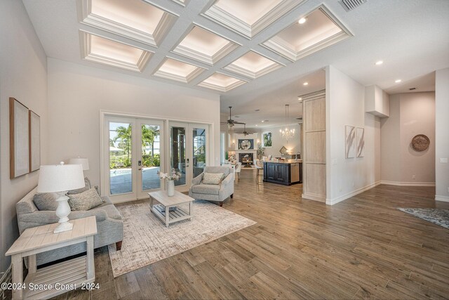 living room with french doors, coffered ceiling, wood-type flooring, ceiling fan, and beam ceiling