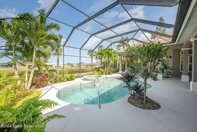 view of swimming pool with glass enclosure and a patio