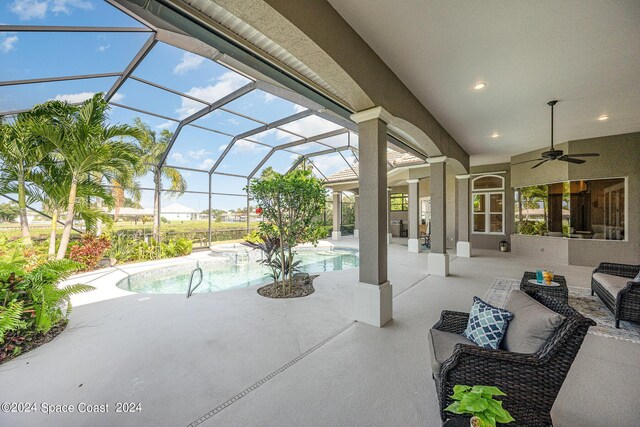 view of patio with ceiling fan, a lanai, and an outdoor living space