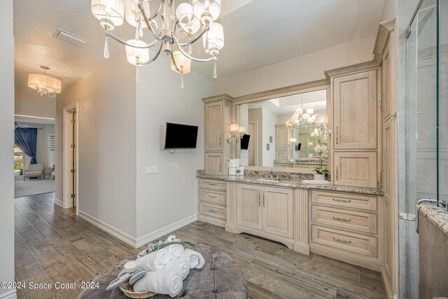 bathroom with hardwood / wood-style floors, a chandelier, a textured ceiling, and vanity