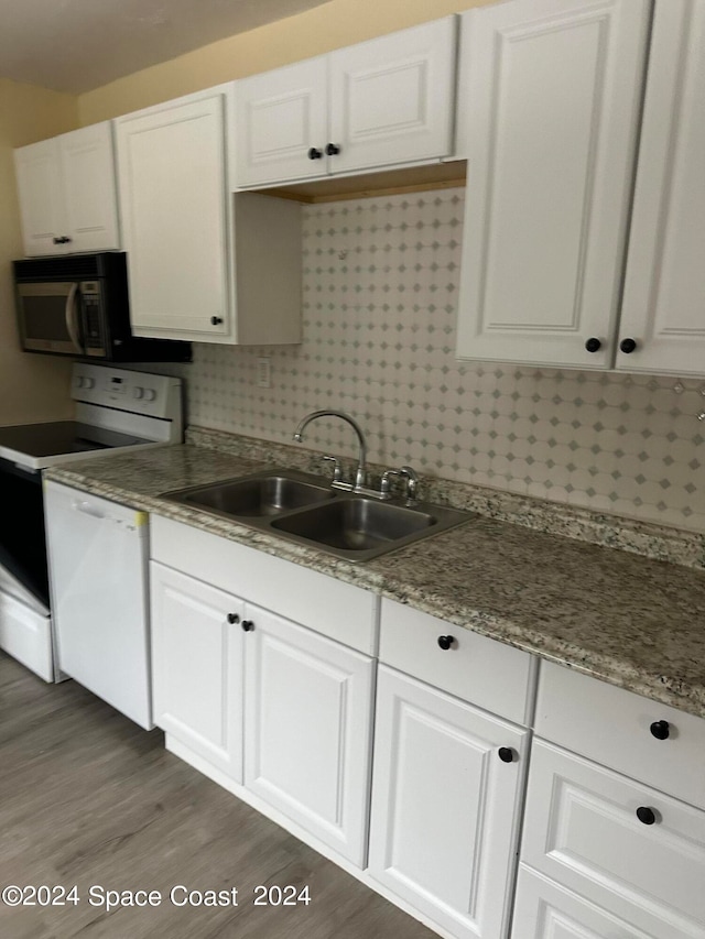 kitchen featuring white appliances, dark hardwood / wood-style floors, white cabinetry, and sink