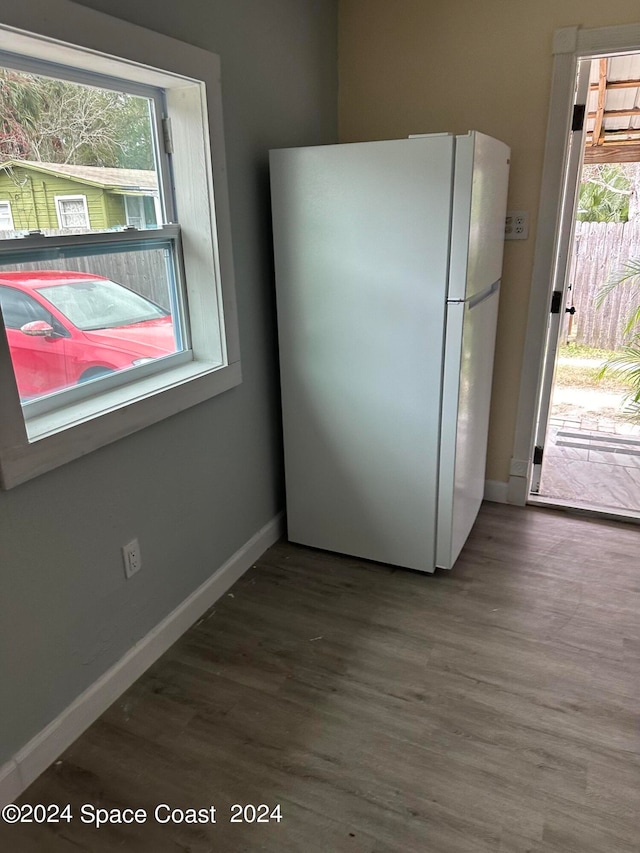 kitchen featuring white refrigerator, plenty of natural light, and dark hardwood / wood-style flooring