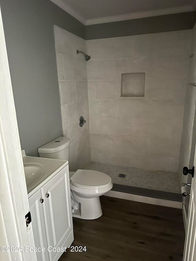 bathroom with tiled shower, vanity, toilet, and hardwood / wood-style floors