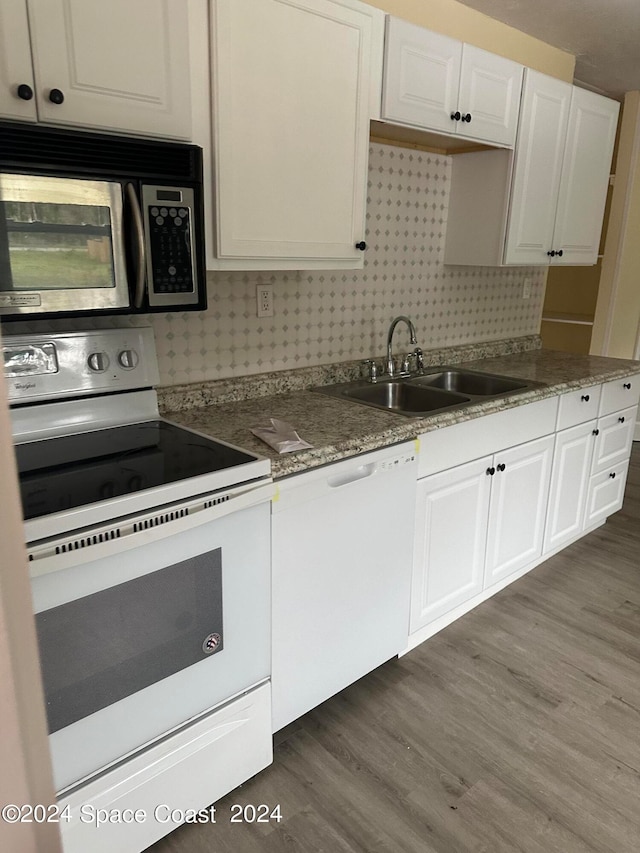 kitchen featuring dark wood-type flooring, white appliances, white cabinetry, and sink