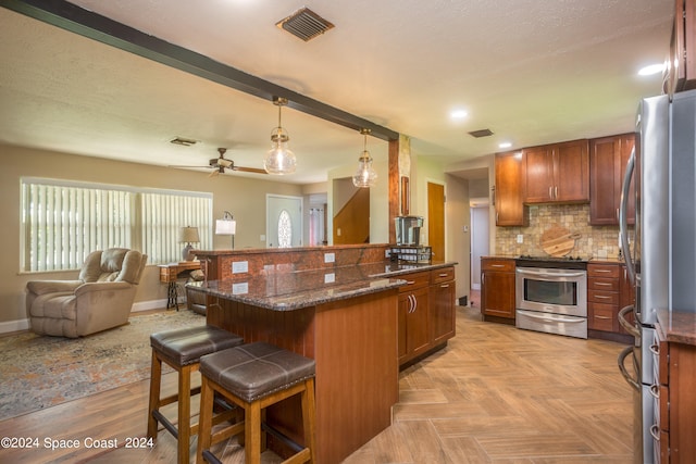 kitchen with stainless steel appliances, dark stone countertops, a breakfast bar, pendant lighting, and tasteful backsplash