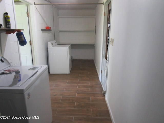 clothes washing area featuring washer / clothes dryer and dark hardwood / wood-style flooring