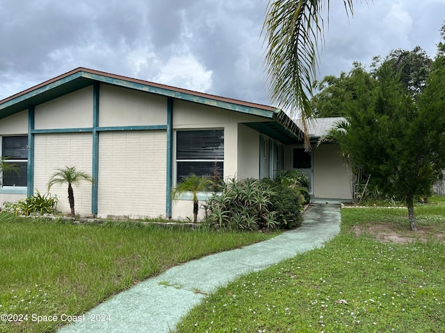 view of side of home with a yard