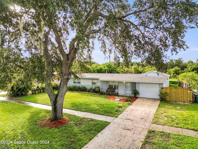 single story home featuring a garage and a front lawn