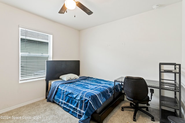 bedroom featuring multiple windows, light colored carpet, and ceiling fan