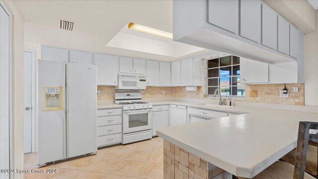 kitchen featuring decorative backsplash, white cabinetry, white appliances, light tile patterned floors, and sink