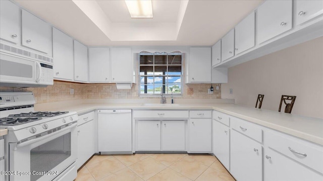 kitchen with white appliances, sink, and white cabinets