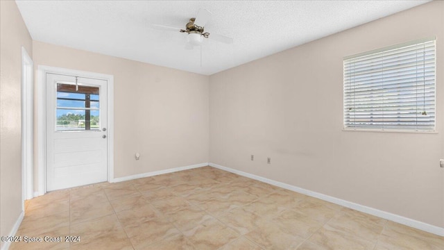 empty room featuring ceiling fan and a textured ceiling