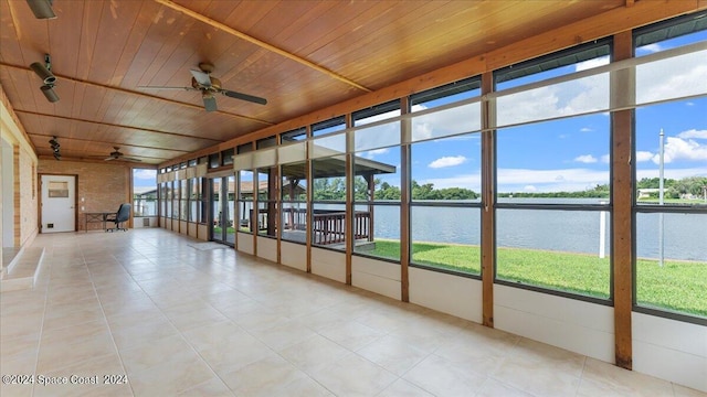 unfurnished sunroom featuring wood ceiling, a water view, ceiling fan, and rail lighting