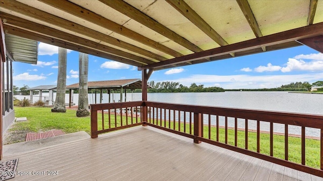 wooden deck with a water view and a yard