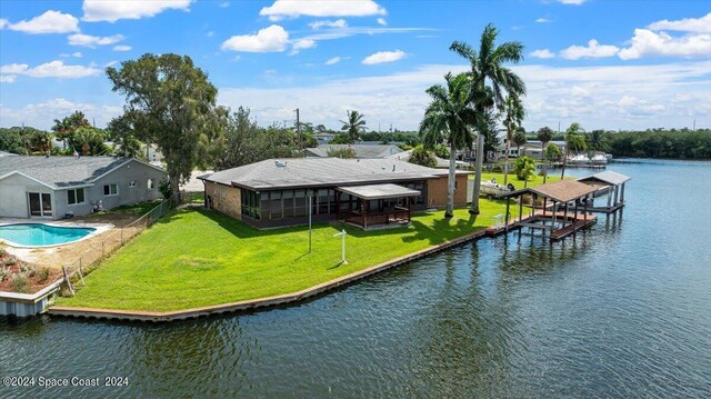 view of dock with a patio, a yard, and a water view