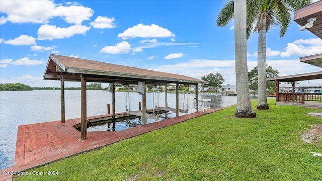 dock area with a lawn and a water view