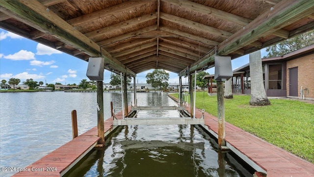 dock area with a lawn and a water view