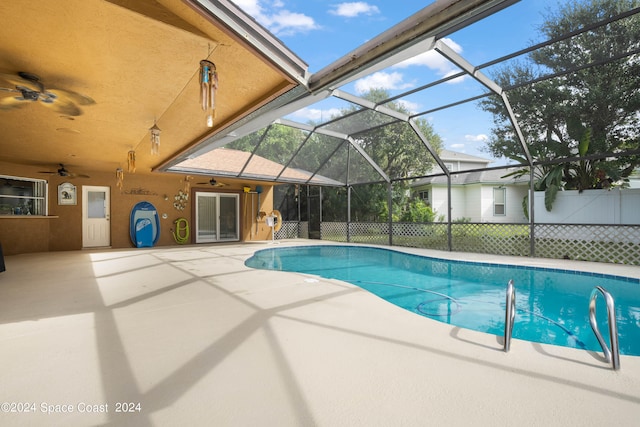 view of pool featuring ceiling fan, glass enclosure, and a patio area