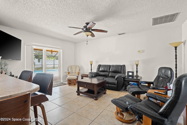 tiled living room featuring a textured ceiling and ceiling fan