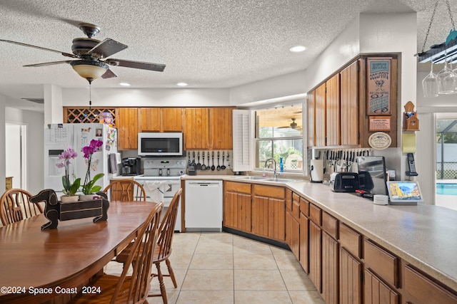 kitchen featuring white appliances, ceiling fan, a healthy amount of sunlight, and a textured ceiling