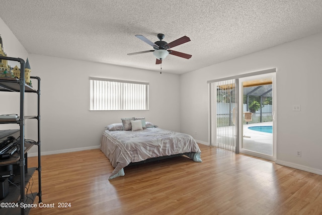 bedroom featuring access to outside, light wood-type flooring, multiple windows, and ceiling fan