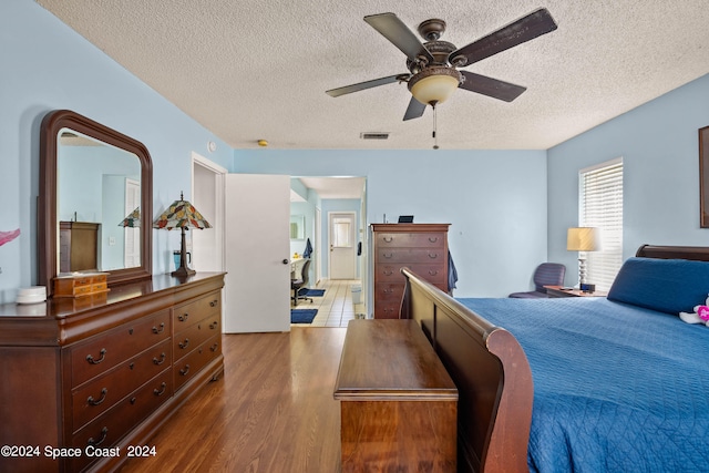 bedroom featuring ceiling fan, a textured ceiling, and hardwood / wood-style floors