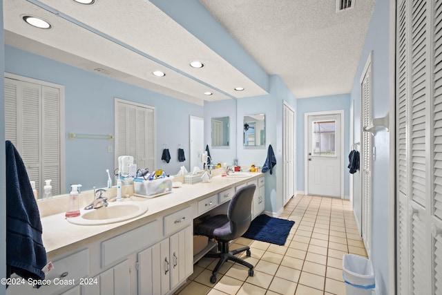 bathroom featuring a textured ceiling, vanity, and tile patterned floors