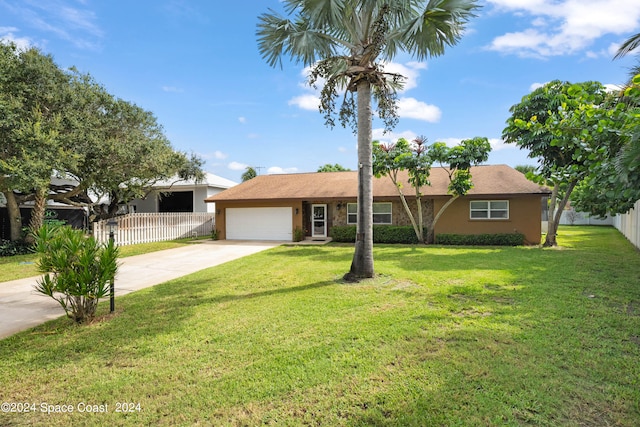 ranch-style house featuring a garage and a front lawn