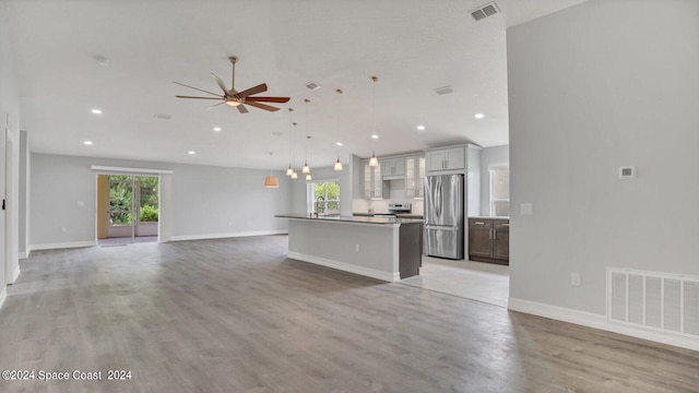 kitchen with a kitchen island with sink, appliances with stainless steel finishes, plenty of natural light, and ceiling fan