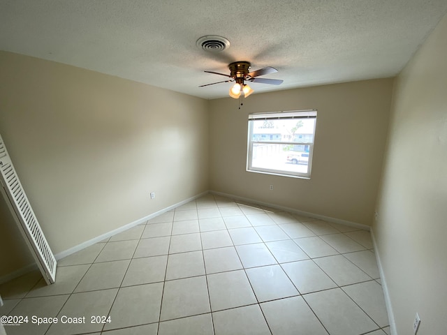 empty room featuring visible vents, baseboards, a textured ceiling, and a ceiling fan