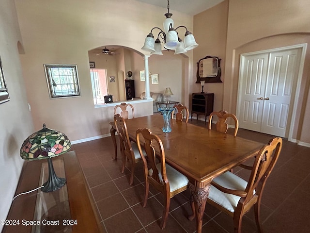 dining room featuring ceiling fan with notable chandelier and dark tile patterned floors