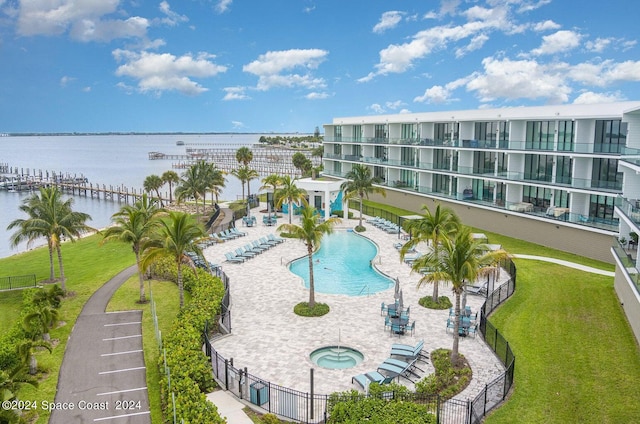 view of pool featuring a patio area, a yard, and a water view