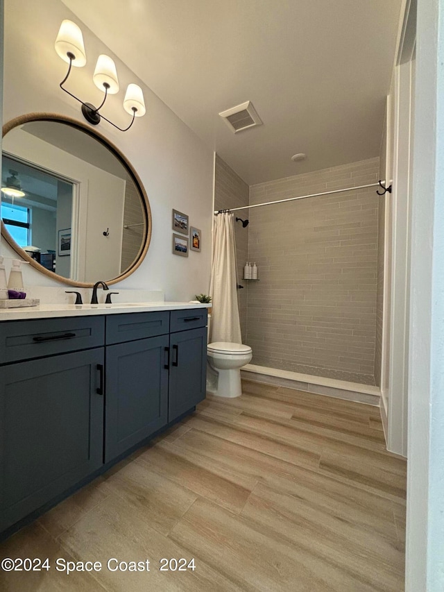 bathroom with wood-type flooring, toilet, walk in shower, and vanity