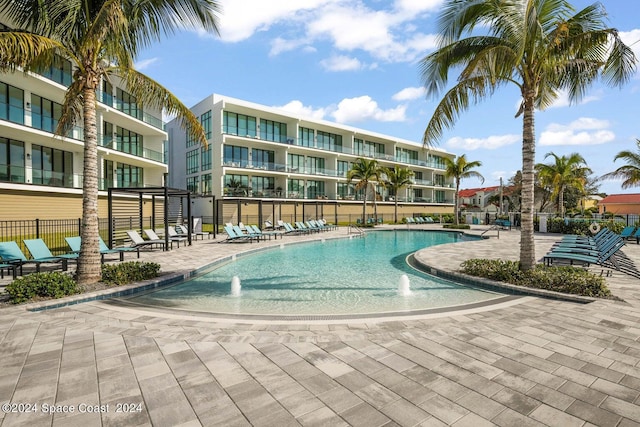 view of swimming pool featuring pool water feature and a patio