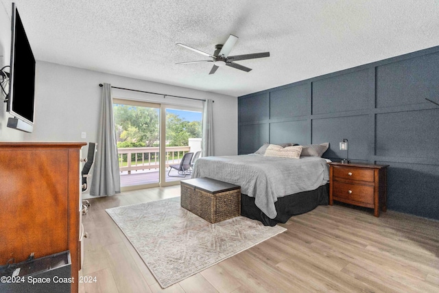 bedroom featuring ceiling fan, light hardwood / wood-style floors, a textured ceiling, and access to outside