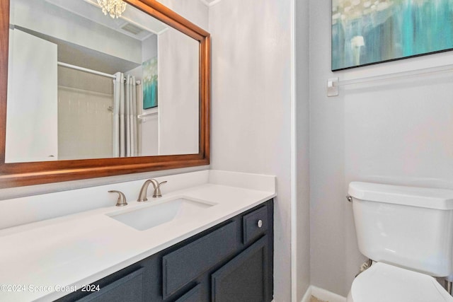 bathroom featuring a chandelier, vanity, toilet, and curtained shower