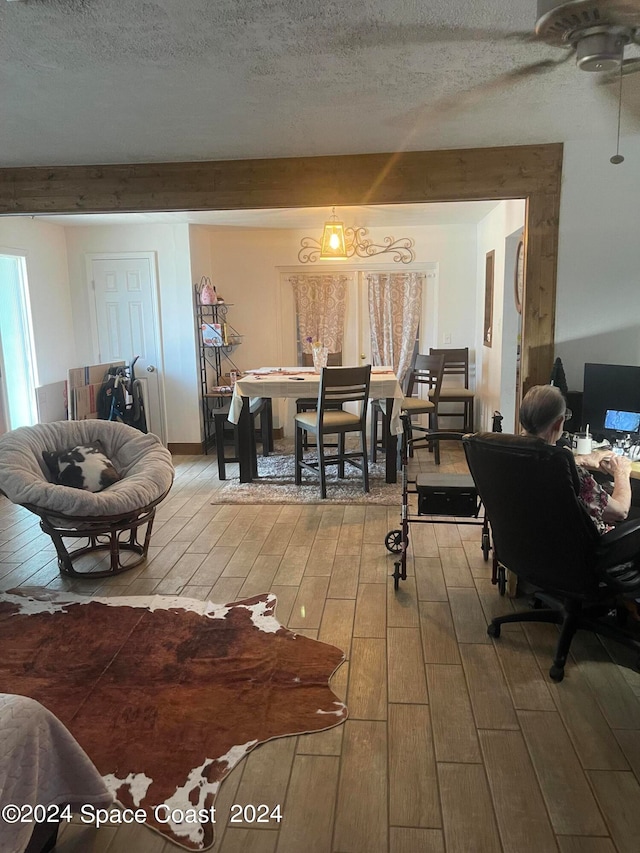 living room with hardwood / wood-style floors, beamed ceiling, and a textured ceiling