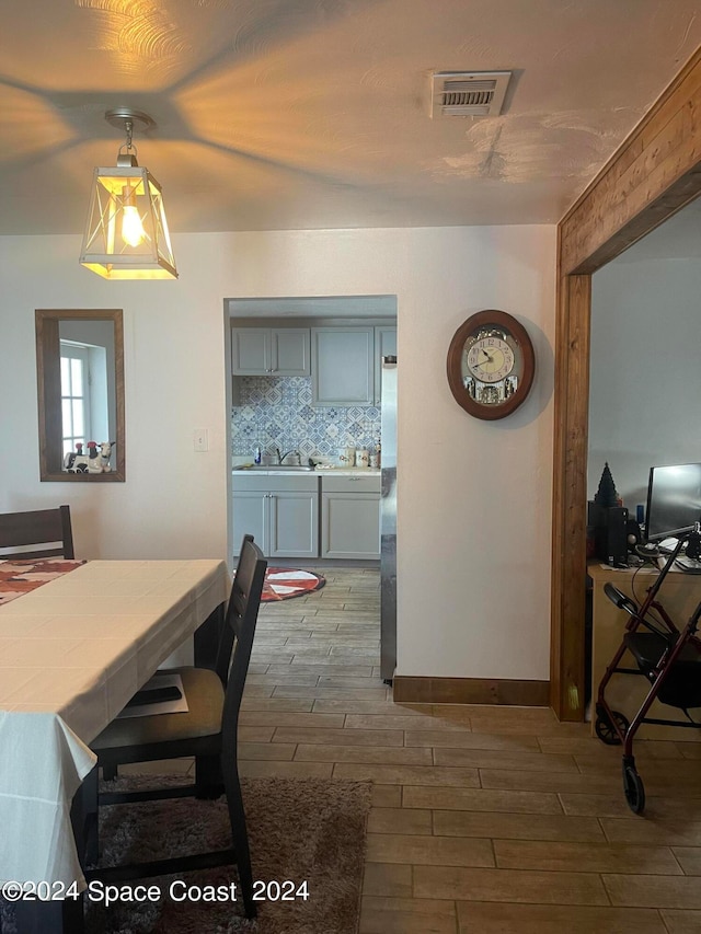 dining space with wood-type flooring and sink