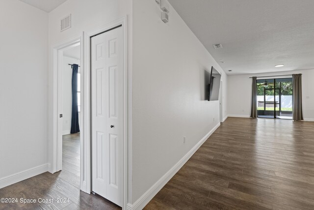 hallway featuring dark wood-type flooring and a textured ceiling