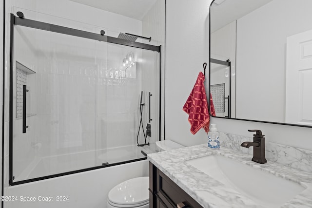 full bathroom featuring shower / bath combination with glass door, vanity, and toilet