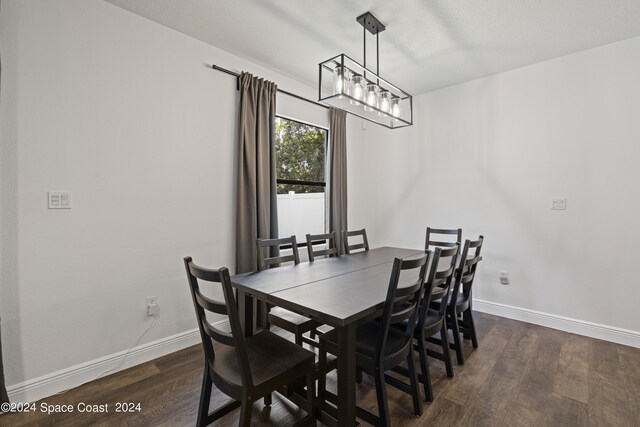 dining area featuring dark hardwood / wood-style floors and an inviting chandelier