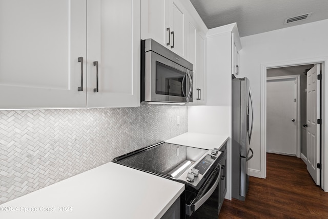 kitchen with a textured ceiling, stainless steel appliances, dark hardwood / wood-style flooring, decorative backsplash, and white cabinets