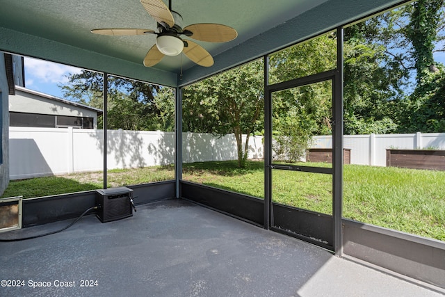 unfurnished sunroom featuring ceiling fan