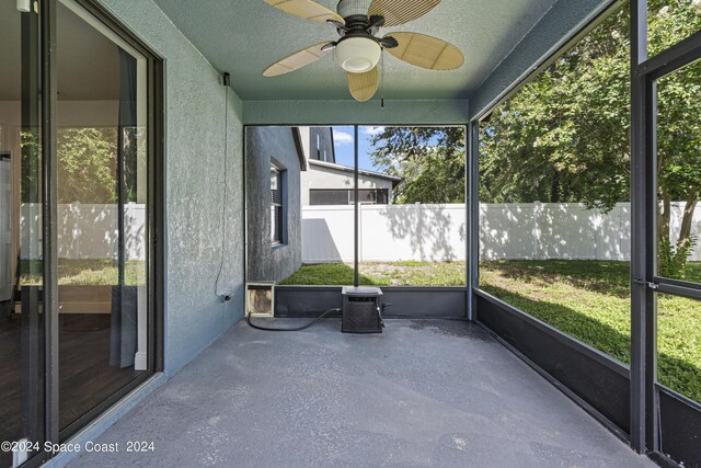 unfurnished sunroom featuring ceiling fan