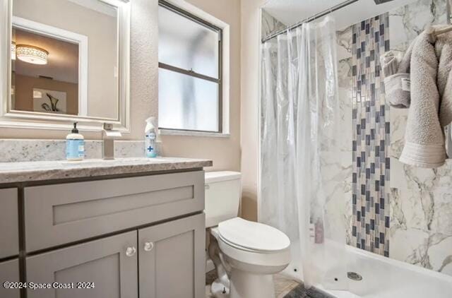 bathroom featuring walk in shower, toilet, and vanity