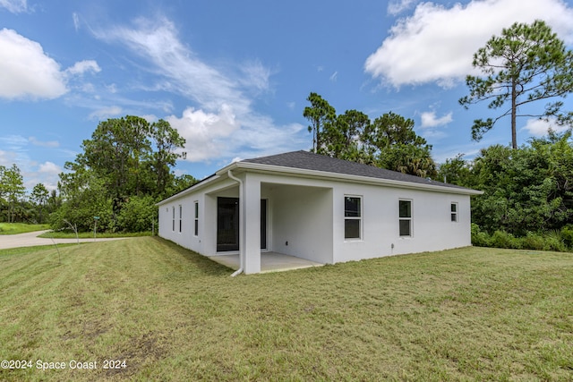 rear view of property with a lawn and a patio area