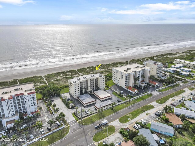 drone / aerial view with a water view and a beach view