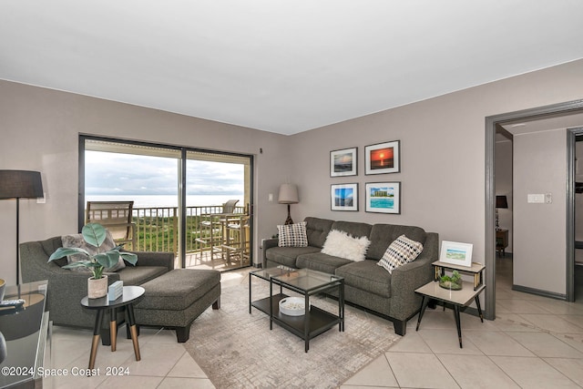 living room featuring light tile patterned floors and a water view