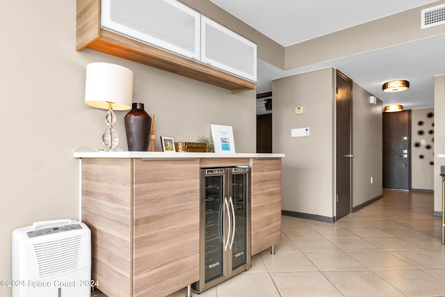 kitchen with beverage cooler and light tile patterned floors