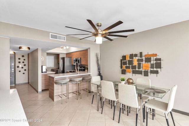 dining room featuring ceiling fan, sink, and light tile patterned floors